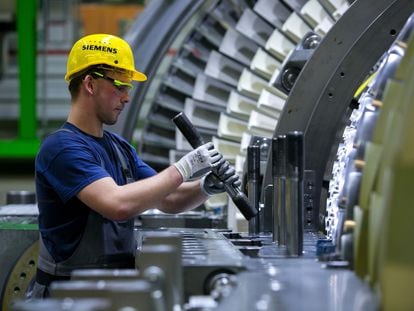 Un operario de una fábrica de Siemens en Berlín comprueba el funcionamiento de una turbina.
