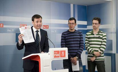 El candidato socialista sostiene un BOCM simulado que informa de la aprobación de la Ley socialista de Movilidad.