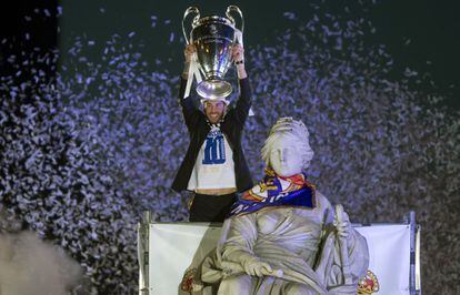 Sergio Ramos levanta el trofeo junto a la estatua de la Cibeles tras colocar alrededor del cuello de la diosa la bufanda del Real Madrid y una bandera.