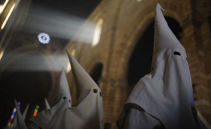 Encapuchados de la hermandad La Borriquita esperan dentro de la iglesia el comienzo de la procesión por las calles de de Córdoba.