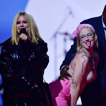 A topless demonstrator is escorted by security after she jumped onstage as Avril Lavigne spoke as the Canadian Academy of Recording Arts and Sciences (CARAS) presents its 52nd annual Juno Awards in Edmonton, Alberta, Canada March 13, 2023. REUTERS/Ed Kaiser