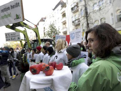 Una joven muestra manzanas dañadas durante una protesta de Greenpeace a las puertas del tribunal administrativo de Berlín el jueves. 