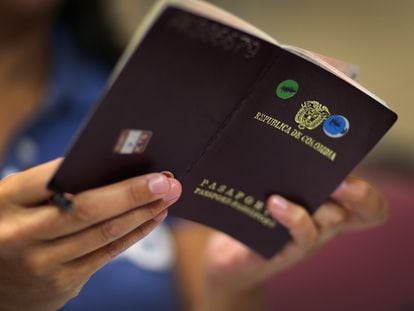 Una persona revisa un pasaporte colombiano.