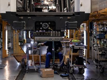 Un empleado trabaja debajo de un vagón de tren en producción en la fábrica de Alstom en Santa Perpètua de Mogoda (Barcelona).