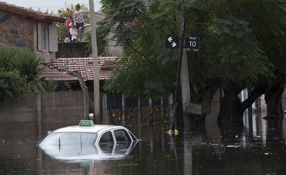 Unas personas esperan en la azotea de su casa ser rescatadas en la ciudad Argentina de La Plata. Más de 35 personas fallecieron por las fuertes lluvias caídas.