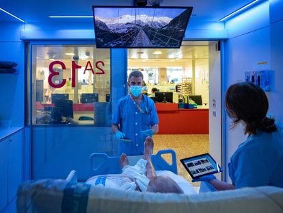 Cristian Lucas, fisioterapeuta, y Patricia del Barrio, terapeuta ocupacional, atienden a un paciente en las nuevas UCI mulisensoriales del hospital de Bellvitge en Hospitalet de Llobregat (Barcelona).