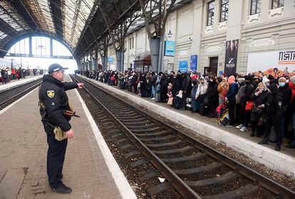 Centenares de personas esperan un tren a Polonia en la estación de Lviv, en el oeste de Ucrania, este sábado. Unas 100.000 personas han cruzado ya la frontera a Polonia desde el comienzo de la invasión rusa de Ucrania, informó hoy el viceministro del Interior polaco, Pawel Szefernaker.