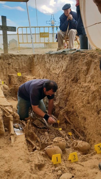 Martín Arnal observa al arqueólogo Javier Ruiz trabajar en la fosa común donde yace, entre otras 25 víctimas, su hermano Román.