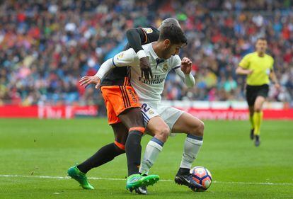 El jugador del Real Madrid Isco es presionado por un jugador del Valencia.