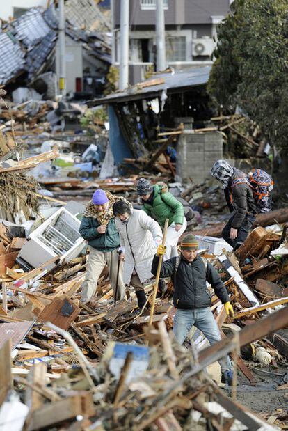Habitantes de Sendai caminan ayer entre los escombros.