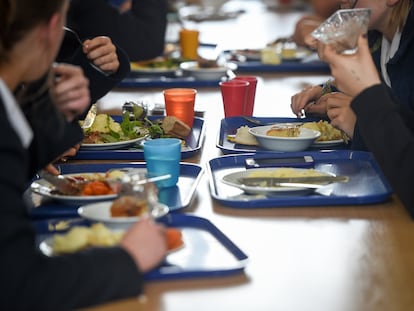 Varios estudiantes comen en sus bandejas en una escuela británica.