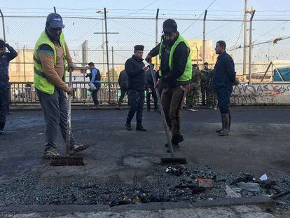 Trabajadores municipales limpian los destrozos dejados por el doble atentado en Bagdad.