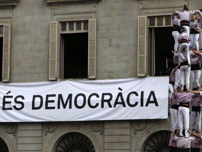 3/09/2017. La colla castellera Minyons de Terrassa levantan una &quot;cuatre de nou amb folre i manilles&quot; ante un cartel que pide &quot;Mas democracia&quot;. 