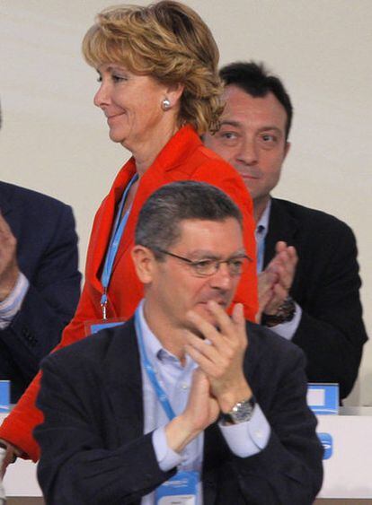 Esperanza Aguirre pasa entre Gallardón y Manuel Cobo durante el Congreso del PP en Valencia.