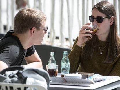 Dos j&oacute;venes beben un refresco en Barcelona.