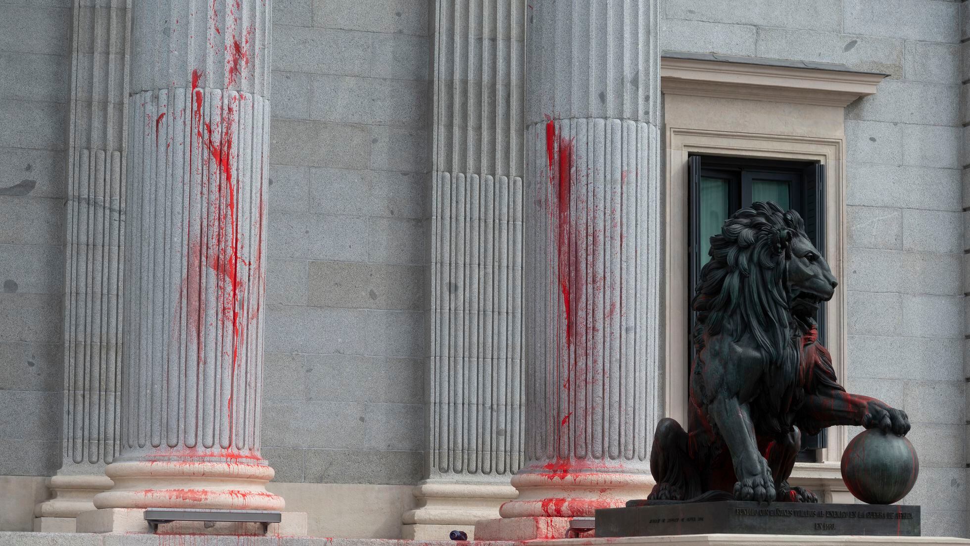 Nueve detenidos por arrojar pintura roja a uno de los leones del Congreso  como protesta por la inacción climática | España | EL PAÍS