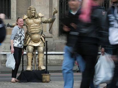 Una turista es fa una foto amb una estàtua de la Rambla.