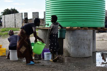 Varias mujeres llenan cubos con agua en un barrio afectado por el brote de cólera en Lusaka. Esta enfermedad diarreica se transmite por el consumo de agua o alimentos contaminados.