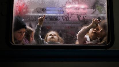 Dos niñas dibujan en el cristal de un vagón en la estación de tren de Lviv, cerca de la frontera de Ucrania con Polonia, el 2 de marzo.