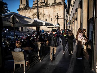 Varias personas pasean y disfrutan de las terrazas frente a la iglesia de San Nicolás, en Bilbao.