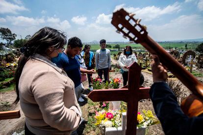 Una familia visita el cementerio de San Miguel Xico el 5 de agosto de 2020, en medio de la pandemia del coronavirus.