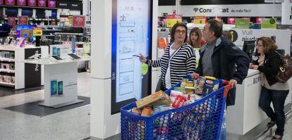 Una pareja compra electrodomesticos en la zona de nuevas tecnologias del centro comercial de Carrefour mientras hacen la compra de la semana. El Prat de Llobregat, 8 de abril de 2016 [ALBERT GARCIA]