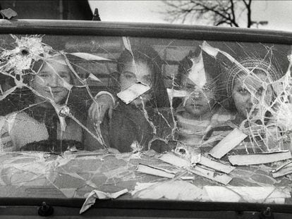 Cuatro ni&ntilde;as miran desde el interior de una furgoneta con el cristal destrozado en Sarajevo.