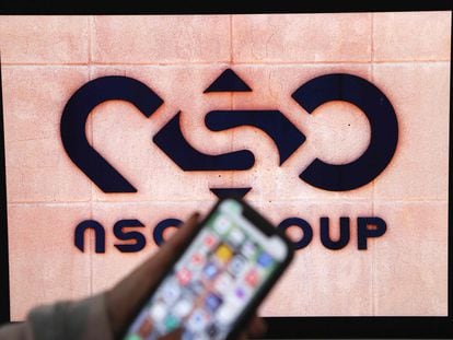 Un móvil frente al logotipo de la empresa israelí NSO Group, creadora del programa Pegasus.