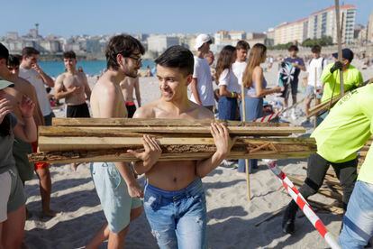 Un joven carga madera para las hogueras este viernes, en A Coruña. 