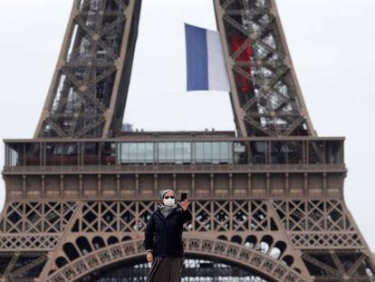 Una monja ataviada con mascarilla se toma un selfie con su teléfono móvil en la plaza del Trocadero, junto a la Torre Eiffel, este lunes en París.