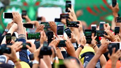 Decenas de personas utilizan sus teléfonos inteligentes para grabar un evento en Ciudad de México.