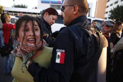 Un polic&iacute;a arresta a una integrante del movimiento Indignados de Ciudad Ju&aacute;rez durante una manifestaci&oacute;n en la que el colectivo pint&oacute; cruces con los nombres de las v&iacute;ctimas de la violencia en esa ciudad.