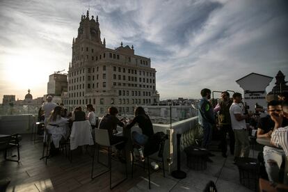 Unos clientes disfrutan del atardecer con vista al edificio de Telefónica en la Gran Vía.