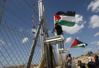 Manifestantes palestinos ubican banderas en la alambrada que Israel ha instalado cerca de Ramala.