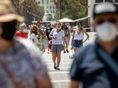 Personas sin mascarilla y con mascarillas en el paseo marítimo de la playa Malvarrosa de Valencia el pasado sábado.