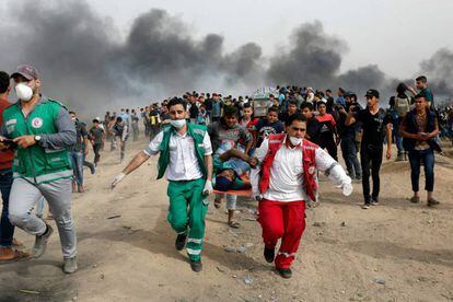 Médicos palestinos evacuan a un manifestante herido en la franja de Gaza este viernes.
