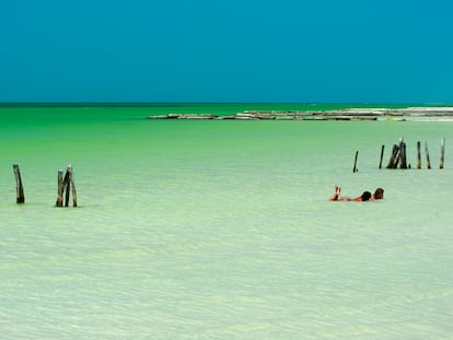 Dos turistas se relajan en las aguas poco profundas de la isla de Holbox (México).