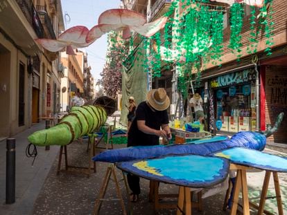 Preparativos de las Fiestas de Gràcia de Barcelona. En la imagen, vecinos de la calle de Verdi trabajando en pleno mediodía.