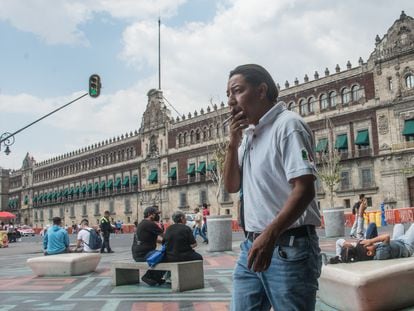 Un hombre fuma un cigarrillo a espaldas de Palacio Nacional, donde ya no se podrá fumar.