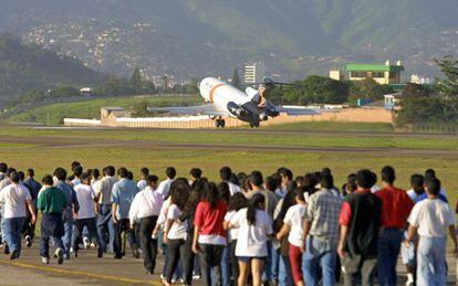 Un grupo de hondure&ntilde;os deportados desde EE UU camina por la pista del aeropuerto de Tegucigalpa. 