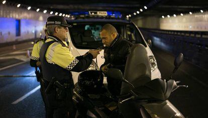 Un agente de la Guardia Urbana de Barcelona hace la prueba de alcoholemia a un motorista.
