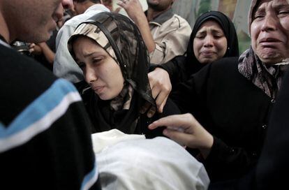 La madre de Omar Ahmed Masharawi, de 11 meses de edad, traslada el cuerpo de su hijo durante su funeral.