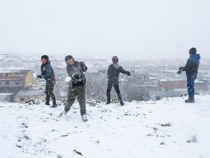 Grupo de niños jugando durante la nevada en la Cañada Real el pasado viernes