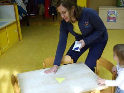 Una educadora del Colegio Pasacalles de Algete (Madrid) limpia una mesa con toallitas impregnadas.