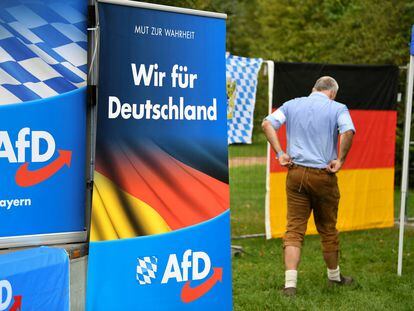 Un simpatizante de Alternativa para Alemania (AfD) camina entre carteles de la formación en la feria de Gillamoos, en Baviera, en 2019.