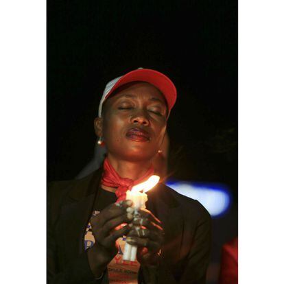 Una activista de &quot;#Bring Back Our Girls&quot; sostiene unas velas durante la vigilia por la doctora Adadevoh y otras v&iacute;ctimas. 