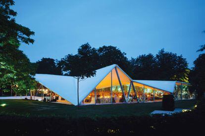 En el año 2000 se cumplía el 30º aniversario de la Serpentine Gallery y para celebrarlo quisieron levantar enfrente de su edificio (de la década de 1930) un pabellón que albergara una cena de gala benéfica. La galería de arte contemporáneo encargó el proyecto a <a href="https://elviajero.elpais.com/tag/zaha_hadid/a" target="_blank">Zaha Hadid</a>, y su diseño tuvo tanto éxito que en vez de ser desmontado al día siguiente se mantuvo abierto todo el verano para que lo pudieran disfrutar quienes visitaban los jardines de Kensginton. La arquitecta de origen iraquí se convertía así en la primera en firmar lo que hoy se conoce como el Serpentine Gallery Pavilion y que es ya una institución en el mundo del diseño y de la arquitectura. La idea de Hadid reinventaba el concepto de tienda o de carpa, y era una simple estructura de metal con un techo triangular de color blanco bajo el que se expandía un espacio de 600 metros cuadrados. En el interior, las mesas diseñadas por la arquitecta en colores negros, grises y blancos jugaban con la idea del color.<br></br> Más información: <a href="http://www.serpentinegalleries.org/explore/pavilion" target="_blank">Serpentine Gallery.</a>