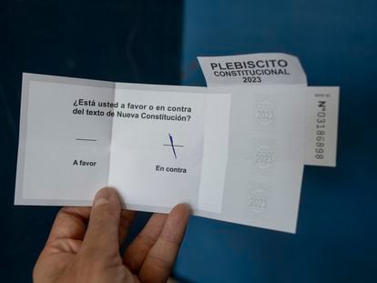 Una persona muestra su voto por la opción 'en contra' en el plebiscito del 17 de diciembre.