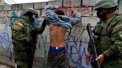 Militares revisan los tatuajes de un hombre.