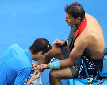 El fisioterapeuta cuida de las heridas que tiene Rafa Nadal en su mano izquierda.